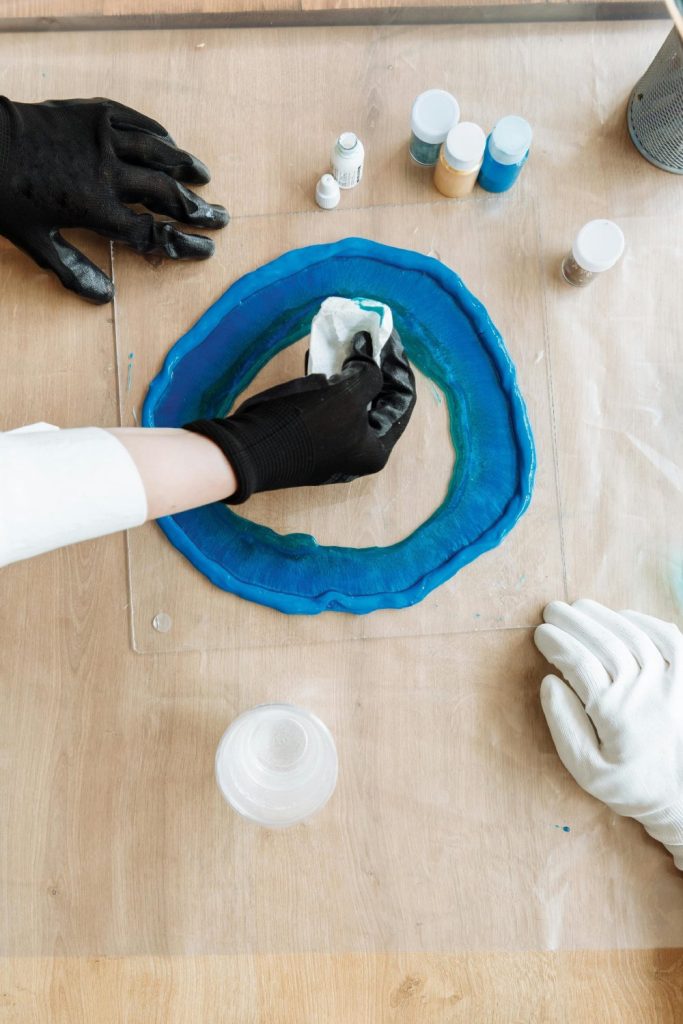 Detailed view of blue resin being poured in an art project, perfect for DIY crafts.